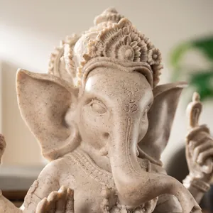 Detailed close-up of a sandstone resin Ganesha statue with intricate carvings and Om symbol