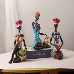 Three-piece African resin female sculptures in vibrant traditional ethnic clothing and jewelry