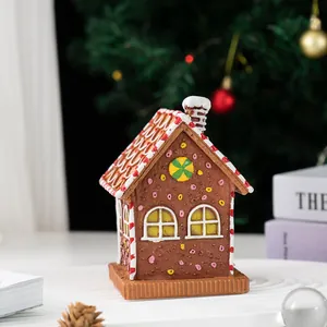 Detailed close-up of a resin Christmas gingerbread house ornament with a red-striped roof