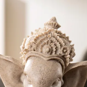 Macro detail of Ganesha statue showing intricate carved crown and sacred Om symbol on forehead