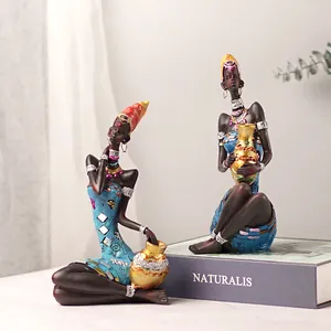 Set of two African resin figurines in blue ethnic dresses with gold pots for home decor