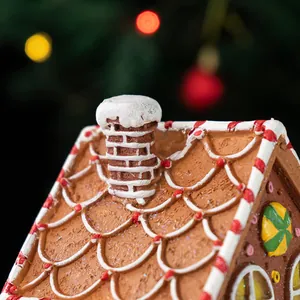 Close-up of resin gingerbread house with candy canes and frosting snow details