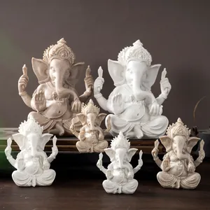Detailed comparison of Ganesha statues in smooth white resin and textured sandstone finishes