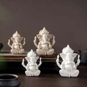 Detail of Ganesha resin statues in white and grey stone finish on a wooden stand
