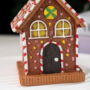 Close-up of resin Christmas gingerbread house ornament with candy cane trim and colorful beans
