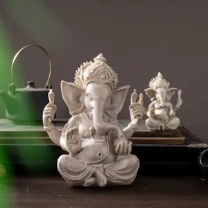 Detail of Ganesha resin statue with sandstone texture in a Zen setting with tea set