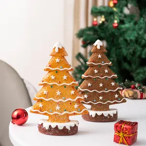 Detail of gingerbread resin Christmas tree ornaments with snow texture and star toppers