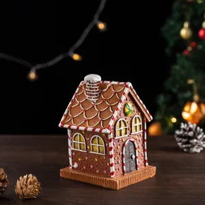 Close-up of resin gingerbread house with snow details and festive bokeh lights