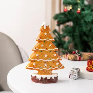 Detail of gingerbread Christmas tree figurine with frosting patterns and snowy base