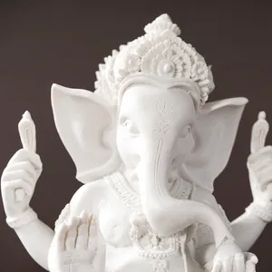 Macro detail of white Ganesha statue showing intricate crown carvings and Om symbol on forehead