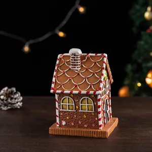 Close-up of resin Christmas gingerbread house with candy details and festive lighting