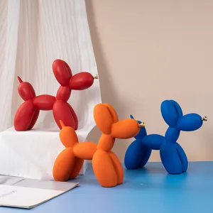 Gros plan sur les statuettes chien ballon rouges oranges bleues avec nez dorés