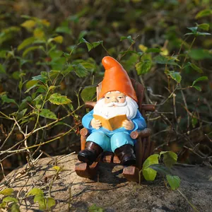 Detailed garden gnome figurine sitting on a wooden chair reading a book in nature