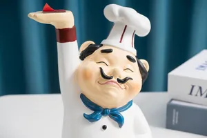 Détail d'une figurine de chef en résine servant de plateau avec une toque blanche