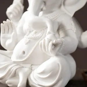 Close-up of a white resin Ganesha statue with intricate carvings and matte finish