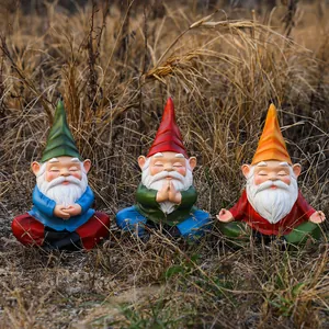 Three-piece set of resin garden gnomes in meditation and yoga poses on autumn grass