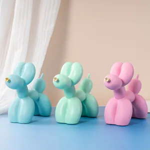 Trois figurines de chien ballon en résine aux couleurs pastel bleu, vert et rose