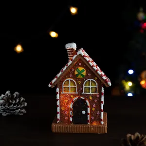 Detailed close-up of a resin gingerbread house with warm LED light glowing inside