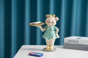 Détail d'une figurine de cochon avec plateau doré pour clés et produits de beauté
