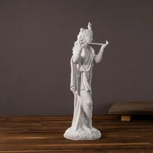 Detailed macro view of white resin Krishna statue playing flute on dark wood surface