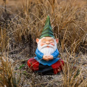 Macro shot of a meditating garden gnome statue on straw background for outdoor decor