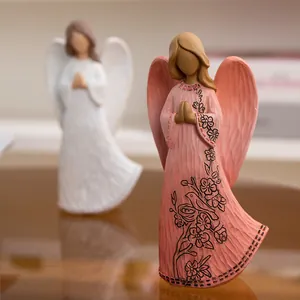 Minimalist resin angel figurines with floral carvings and translucent wings in soft pink