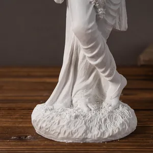 Macro detail of white Krishna resin statue showing intricate drapery and floral base