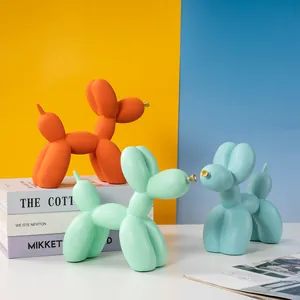 Détail de chiens ballons en résine mate orange, vert et bleu avec museau doré élégant
