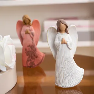 Handcrafted resin angel figurines set in prayer pose with floral relief for home decor