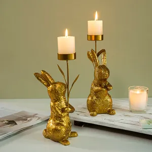 Detail of golden resin rabbit candle holders featuring embossed leaf texture and candles