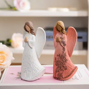 Close-up of resin angel statues with floral patterns and carved wood texture for home decor