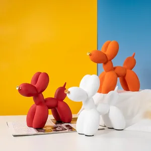Vue détaillée de statuettes de chiens ballons en résine rouge, blanc et orange sur fond moderne
