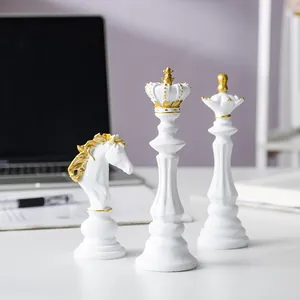 Nahaufnahme von weißen und goldenen Schachfiguren aus Harz auf einem Schreibtisch als Deko
