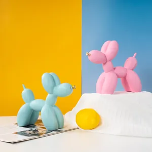 Détail artistique de chiens ballons en résine bleue et rose avec museaux dorés stylisés