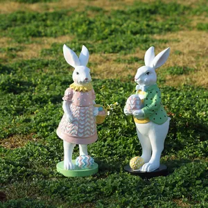 Detalle de conejitos de Pascua de resina pintados a mano en césped con huevos y cestas