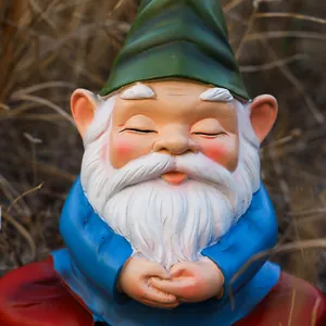 Close-up of a meditating garden gnome resin figurine on grass with detailed textures