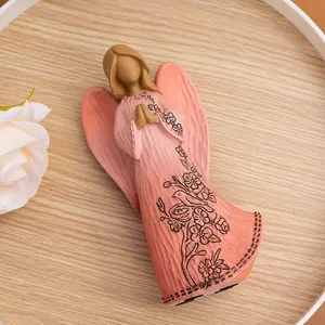 Detail of pink resin angel statue with hand-painted birds and wood-carved texture