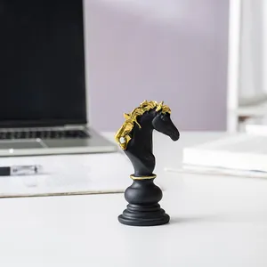 Detailansicht der Schachfigur Springer aus Kunstharz in Schwarz und Gold auf dem Schreibtisch