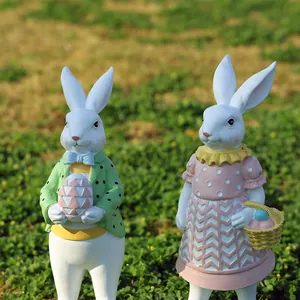 Primer plano de figuritas de resina de conejos de Pascua en un césped de jardín