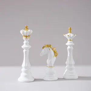 Detailansicht matter weißer Schachfiguren aus Harz mit Goldakzenten von König Dame Springer