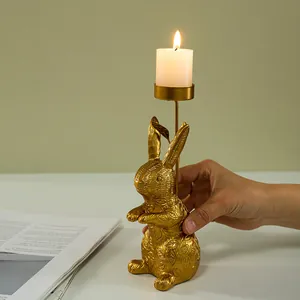 Detail of golden bunny candle holder with leaf texture showing size relative to a hand