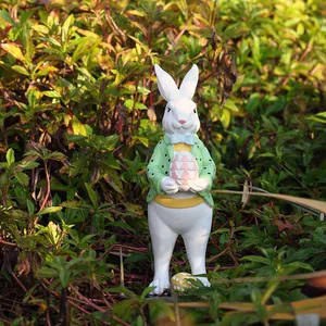 Detalle de figura de conejo de Pascua con huevo rosa decorando un jardín exterior