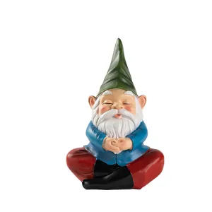 Close-up of hand-painted resin garden gnome in a meditating pose with a green hat