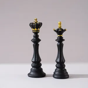 Detailansicht der matt schwarzen Schachfiguren aus Harz mit goldenen Kronen für Deko