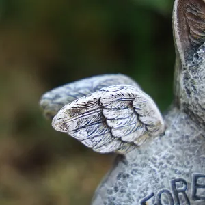 Détail macro d'ailes gravées et texture de résine sur pierre commémorative d'animal de jardin
