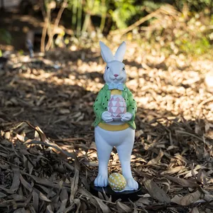 Detalle de una figura de conejo de Pascua con abrigo de lunares y un gran huevo pintado