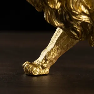 Detailed close-up of golden lion statue showing intricate muscle and paw texture