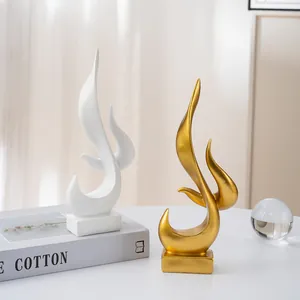 Modern abstract flame resin sculptures in gold and white with steady square bases
