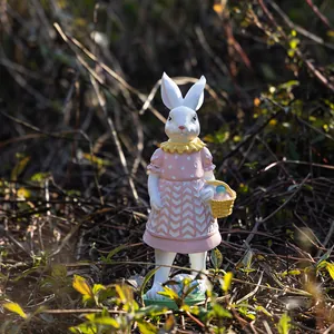 Detalle de una figura de conejo de Pascua de resina con cesta de huevos en un jardín exterior