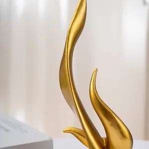 Close-up of golden abstract flame sculpture with metallic texture for modern home decor